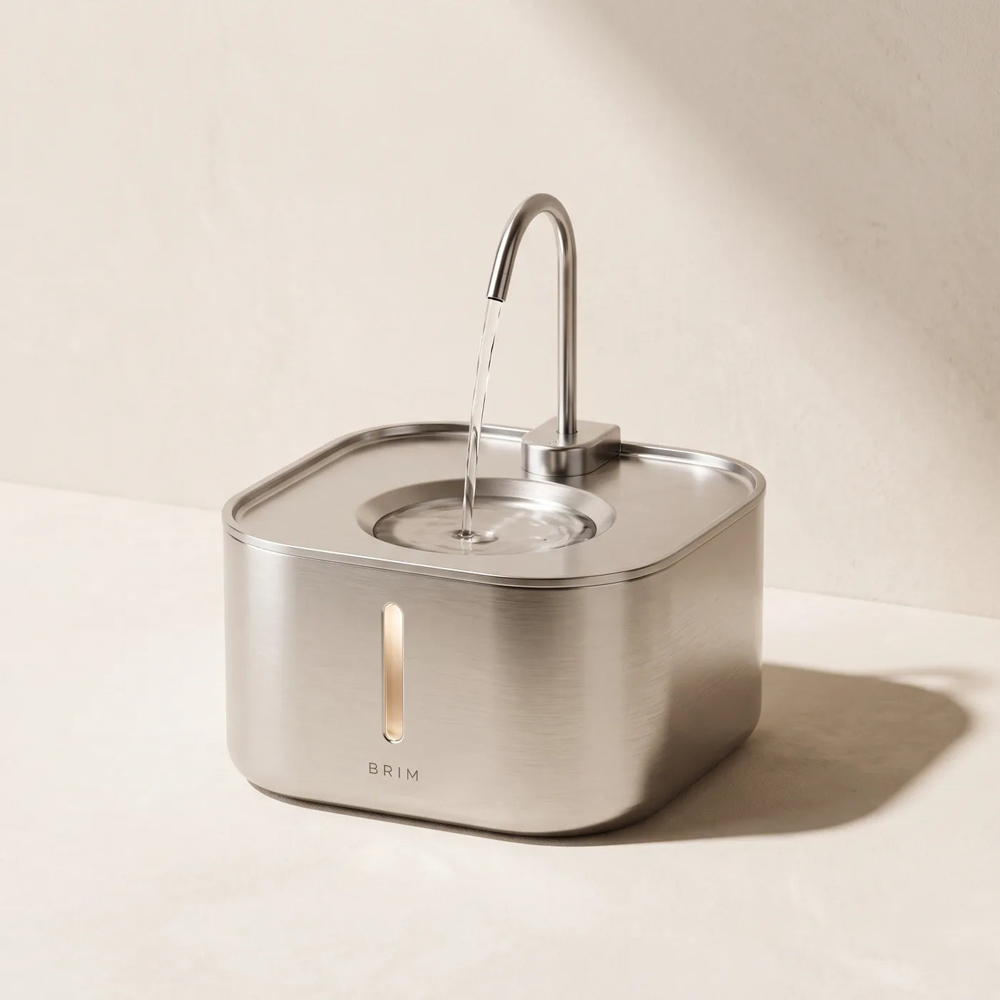 The BRIM stainless steel cat drinking fountain, shown on a stone surface